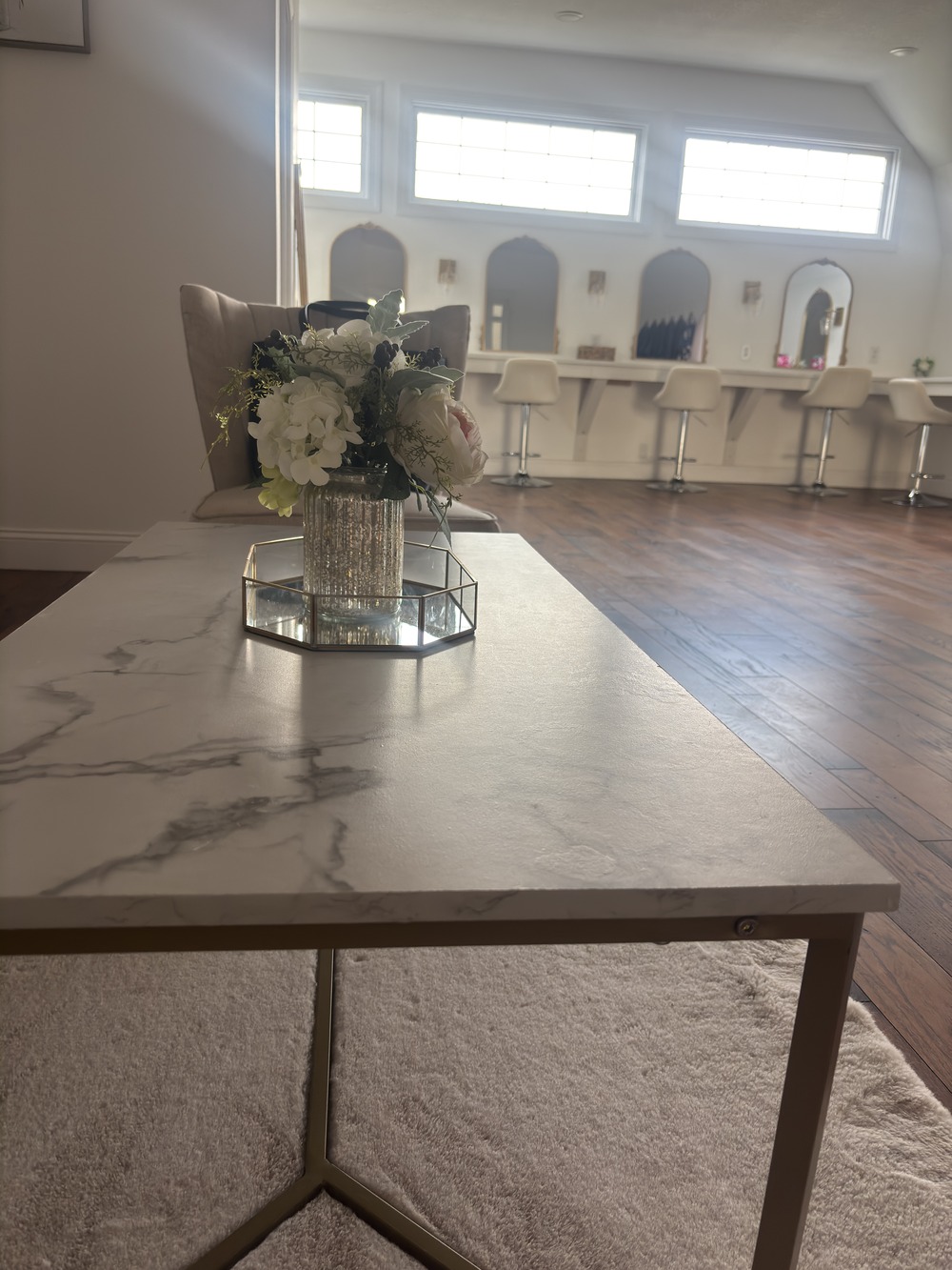 Well lit room with a marble top table and flowers designed for bridal party