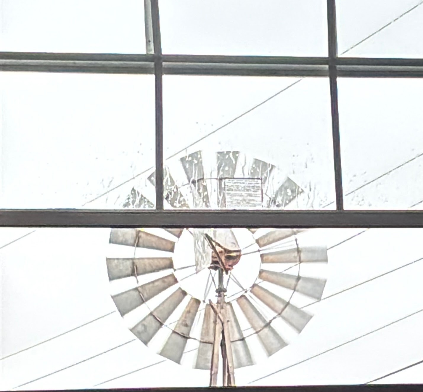 view out a window of windmill in the rain