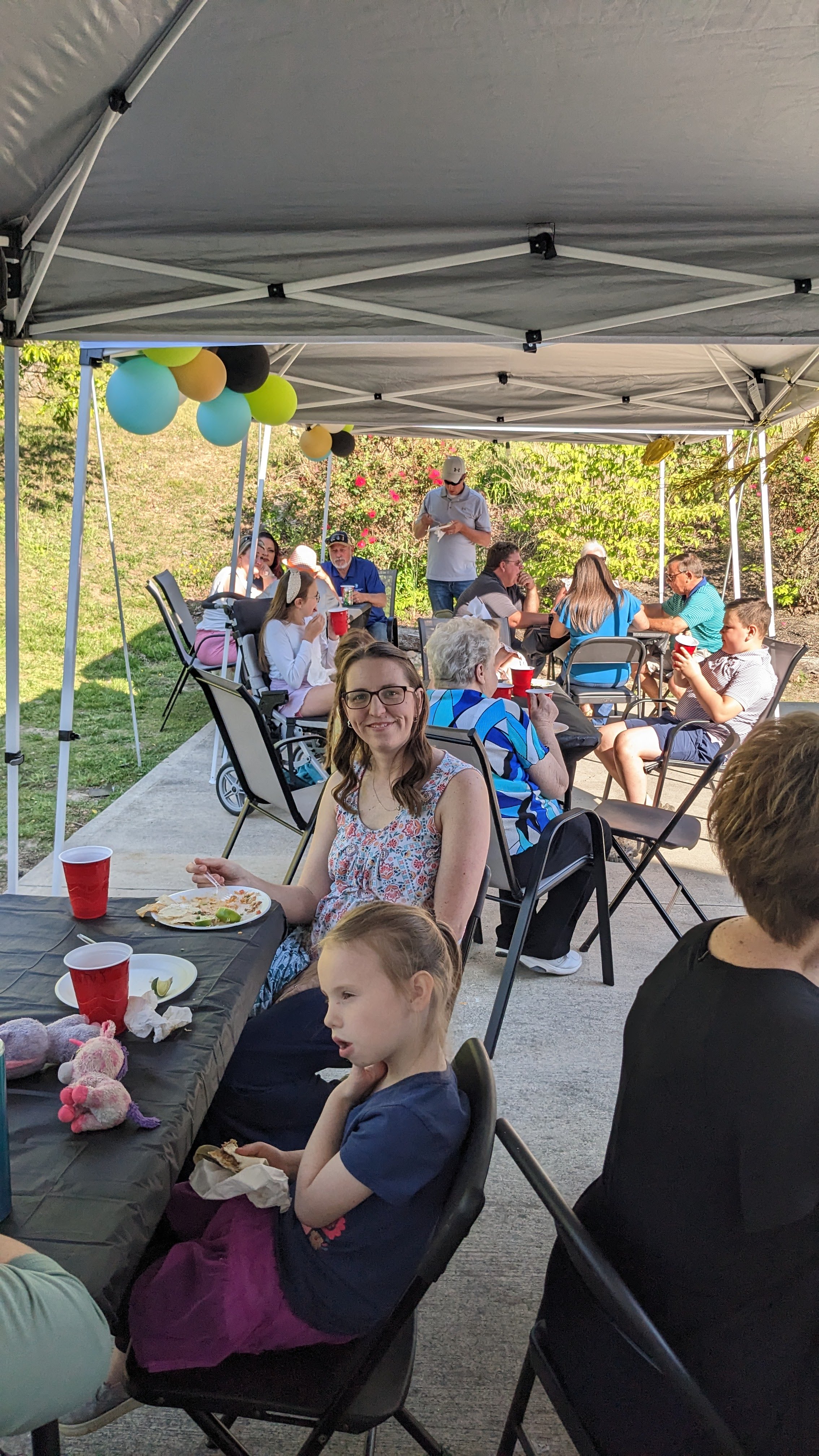Guests sitting in a variety of chairs at an outdoor graduation party